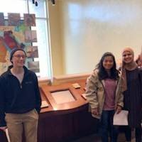 five students in front of a map of Africa at the Arab American Museum
